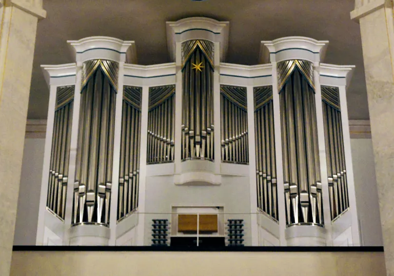 Orgelempore der Luisenkirche mit weißer Orgel und silber-glänzenden Orgelpfeifen.