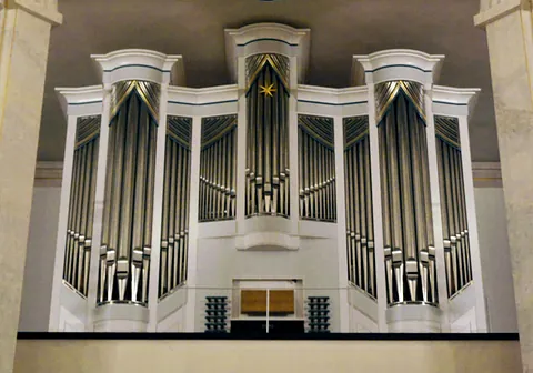 Orgelempore der Luisenkirche mit weißer Orgel und silber-glänzenden Orgelpfeifen.